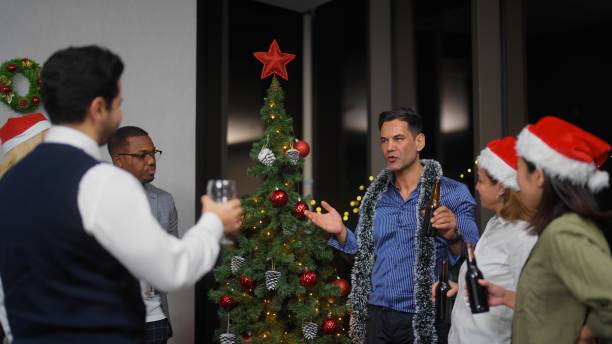 homme d’affaires prononçant un petit discours avant de porter un toast festif tout en organisant une fête de noël après le travail au bureau - after work beautiful people beer beer bottle photos et images de collection