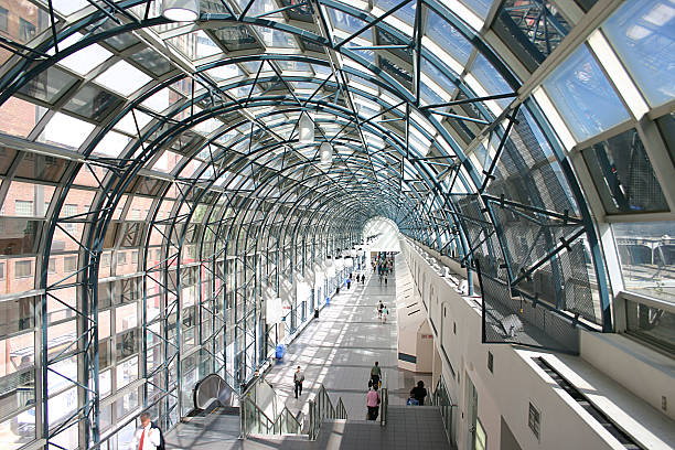 A glass walkway with people walking through it
