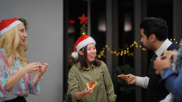 groupe d’hommes d’affaires multiraciaux appréciant de manger une pizza et de célébrer noël ensemble au bureau après le travail - after work beautiful people beer beer bottle photos et images de collection