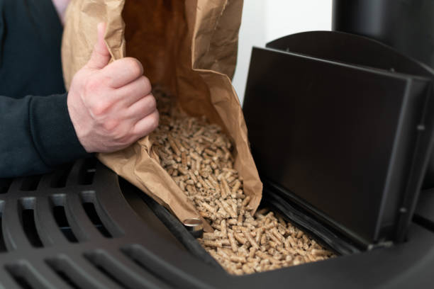 istock Man loading pellet stove with granule bag 1441878388