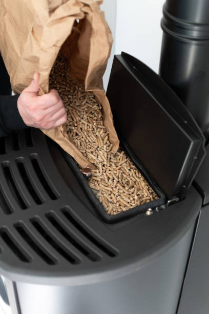 istock Man loading pellet stove with granule bag 1441878394