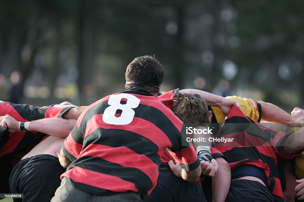 A group of male rugby players tackling each other  Back of a rugby scrum, powerful team work in action New Zealand Stock Photo