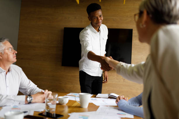 istock Multiracial team shaking hands in corporate board meeting 1441881375