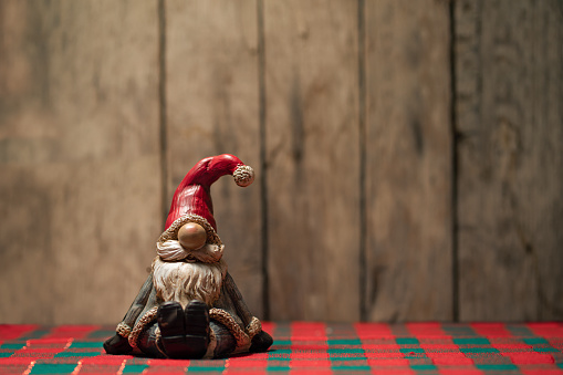 Ceramic figure of Santa Claus in front of old wooden background, Christmas table decoration