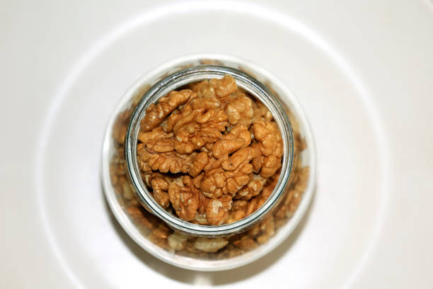 Glass bowl filled with Organic walnuts table top view shot taking using Canon EOS 5D Mk III and Canon EF 70-200 mm f/2.8L Macro IS USM.