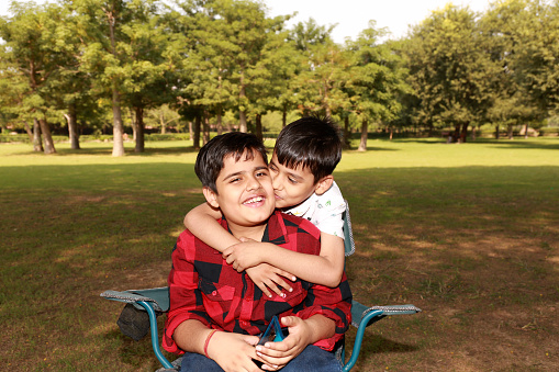Two elementary age children of Indian ethnicity loving portrait outdoor in nature.
