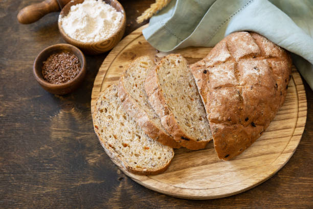 istock Homemade baking. Bread from whole wheat grains, wheat bran, seeds, bio-ingredients over rustic table background, healthy lifestyle. Copy space. 1441883120