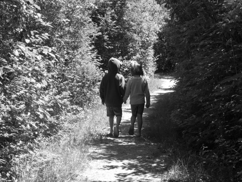 Children walking down a shaded path.