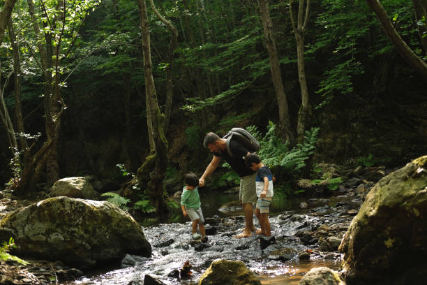 istock Father with son exploring river in a tropical forest. 1441884487