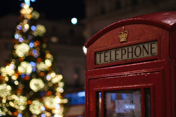 istock Red Telephone Booth Against Christmas Tree In Illuminated City 1441884577