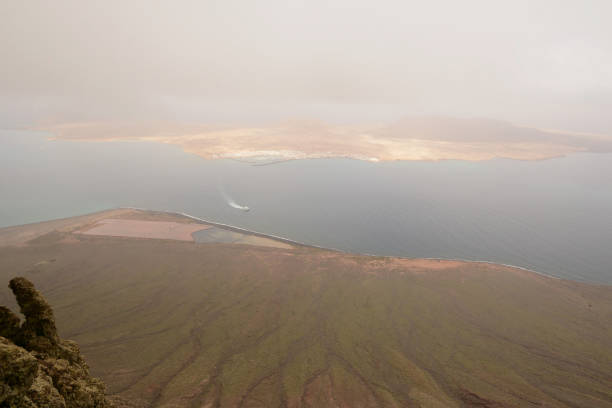 Lanzarote aerial view: wide angle picture , you are looking from mirador del rio toward island  La Graciosa. In the background an out of focus  volcanic crater.