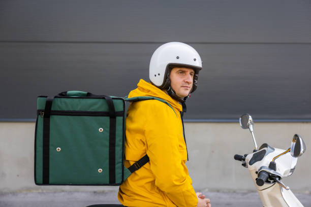 istock Delivery person on scooter taking break from work 1441884764