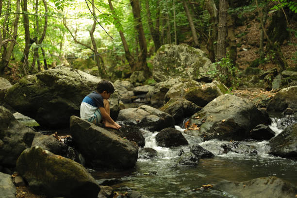 istock Father with son exploring river in a tropical forest. 1441884931