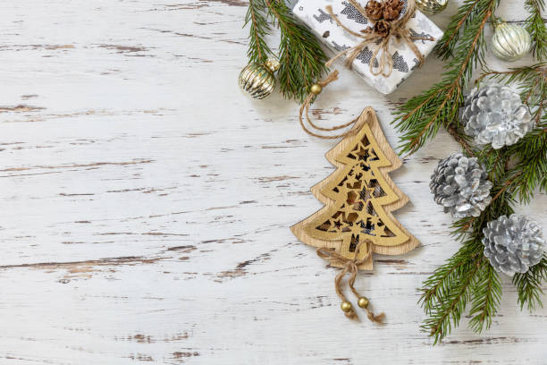 decoración navideña en oro, ramitas de abeto y caja de regalos sobre un fondo de madera blanca. vista desde arriba. - 30057 fotografías e imágenes de stock