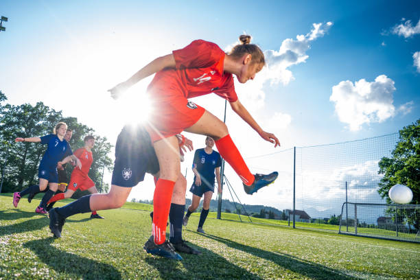 istock Red team member taking a ball and kicking it forward towards a goal 1441886026