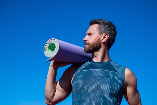 istock sports and healthy lifestyle routine. male athlete do morning exercise. yoga workout. sportsman with yoga mat outdoor. health care. muscular guy do sport. man in sportswear 1441886217