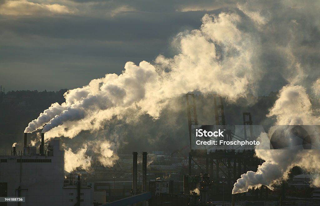 Smokestacks A pulp mill in the Pacific Northwest steam emissions is backlit by the sunrise Back Lit Stock Photo