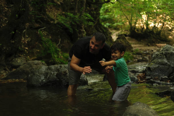 istock Father with son exploring river in a tropical forest. 1441891456