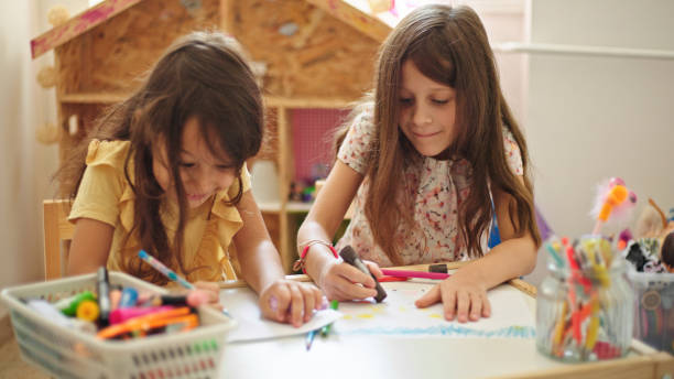 istock Sisters at home drawing and painting together 1441891667