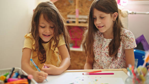 istock Sisters at home drawing and painting together 1441891690