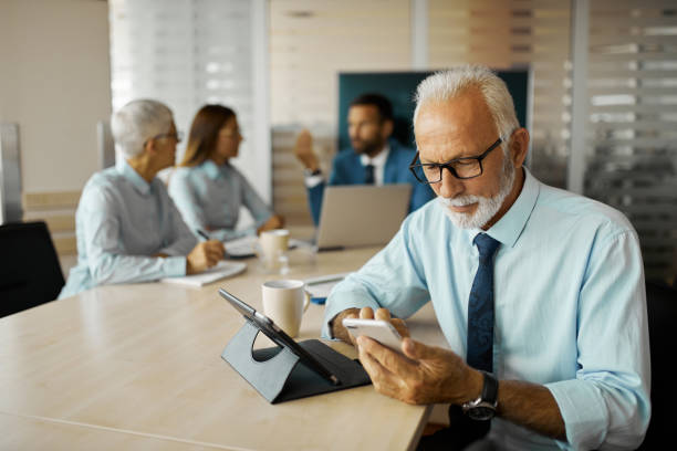 istock Senior businessman using mobile in the office 1441892344