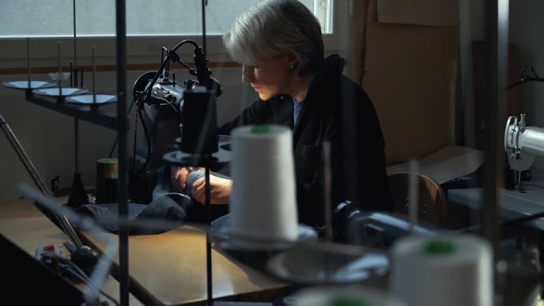 A female tailor seamstress repair old jeans