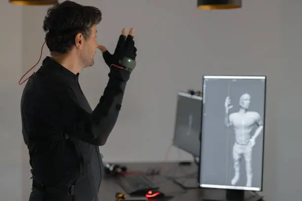 Young Creative designer working on new animation, using a mock-up smart suit, transfering moves to computer