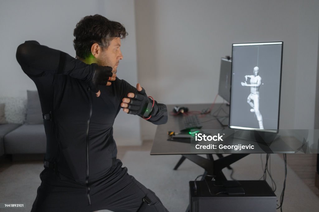 A Caucasian guy is creating a 3d animation by using a mock-up smart suit. Young Creative designer working on new animation, using a mock-up smart suit, transfering moves to computer 35-39 Years Stock Photo