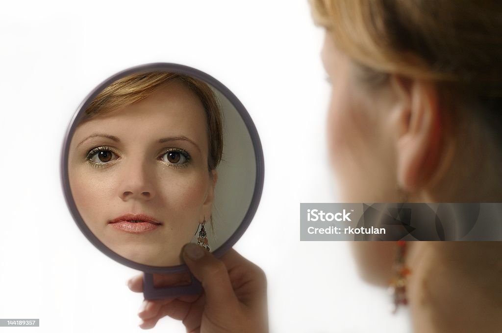 mirror and woman Woman looking in to the mirror Adult Stock Photo