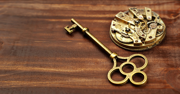 Gold vintage key with clock mechanism, escape room game banner