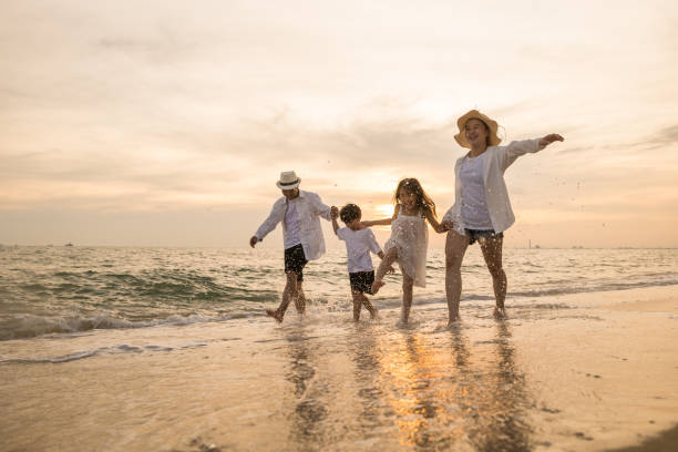 istock Happy family having fun running on a sandy beach at sunset time 1441894572
