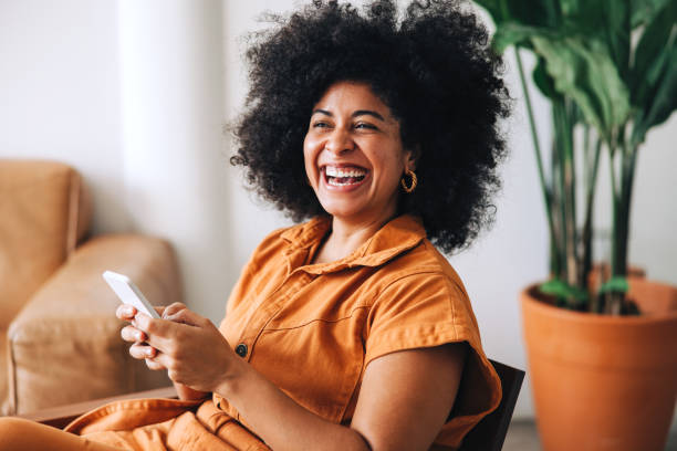 istock Female entrepreneur smiling happily while holding a smartphone 1441895557