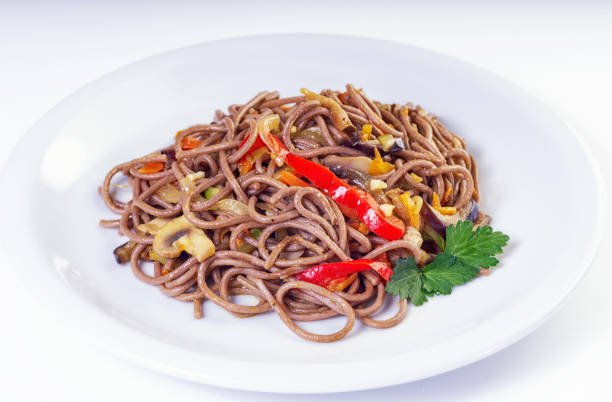 istock Whole grain pasta with vegetables, mushrooms in white plate on light background. 1441896699