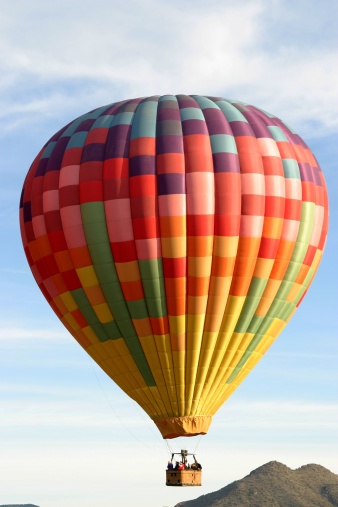 Hot air balloon soars in Arizona desert.