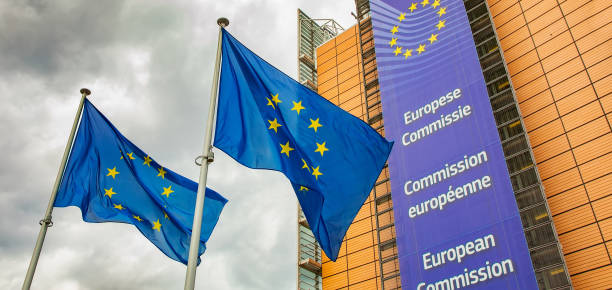 banderas de la unión europea y cielo sombrío sobre el edificio de la comisión europea, concepto de crisis de europa - euro symbol crisis time debt fotografías e imágenes de stock