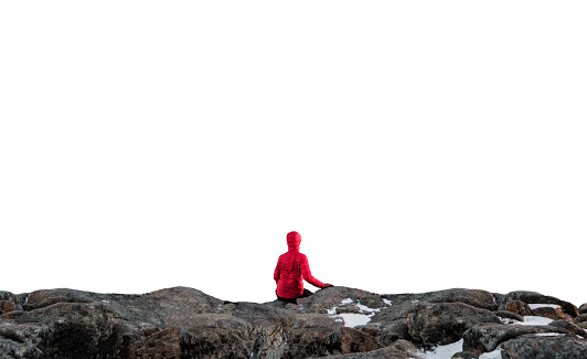 Rear view of Mountaineer in red jacket sitting on the stone cliff and white background for montage