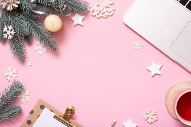 istock Office work table with Cristmas and New Year decoration top view, flat lay on pink background. Copy space for text during winter holidays 1441900443