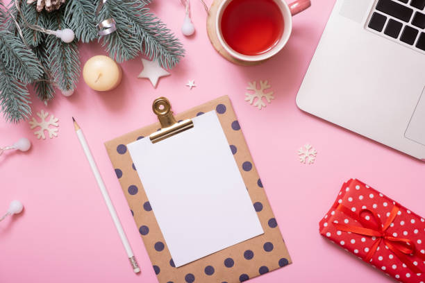 istock Blank paper on tablet and Cristmas New Year work table decoration top view, flat lay on pink background 1441900445