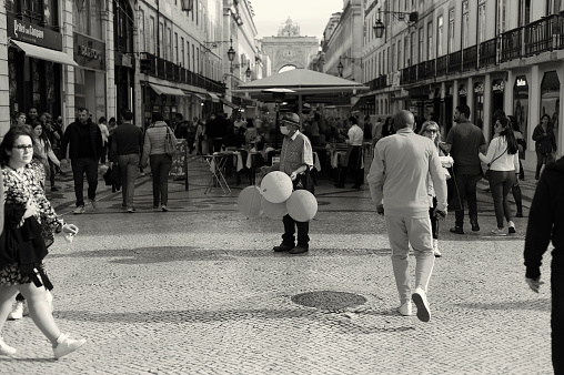 Lisbon, Portugal - April 2, 2022: A man sells ballons at the Rua Augusta street in Lisbon downtown.