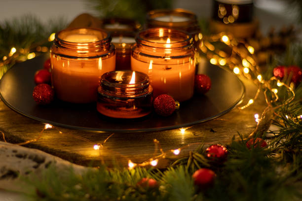 Les bougies de soja brûlent dans des bocaux en verre. La soirée est sombre. Aromathérapie et relaxation. Confort à la maison. Bougie dans un pot brun. Parfum et lumière. Bougie parfumée faite à la main. Aromathérapie - Photo