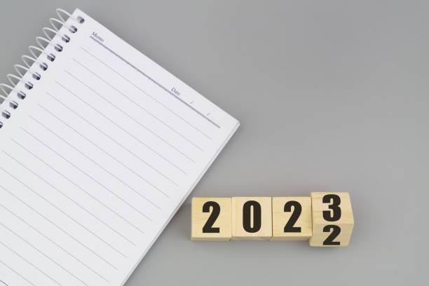 istock Numbers 2022 and 2023 with blank notebook on gray background. 1441904133