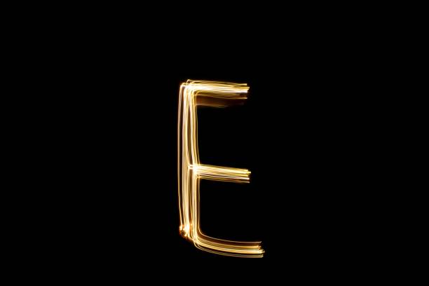 istock Light painting yellow letter E on black background 1441906619