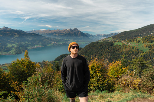 Young Caucasian man hiking  on the background of Interlaken in Swiss Alps