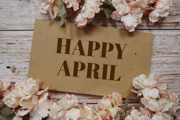 istock Happy April typography text with flowers frame on wooden background 1441908345