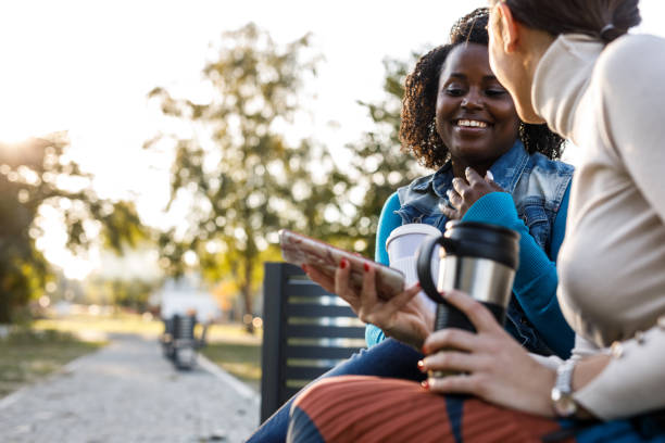 istock Two girlfriends having coffee, bonding and laughing over memes they are looking at via smart phone 1441908559