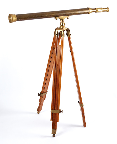 Old brass telescope on white background.