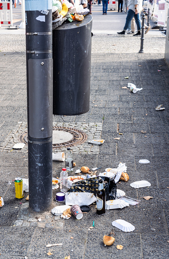 Litter from fast food and other waste spilling from a street bin in central Berlin, Germany.
