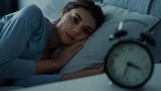 Photo of Insomniac young woman in bed