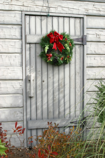 Christmas wreath on off-white barn door.