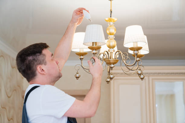 istock A male electrician changes the light bulbs in the ceiling light. 1441912948